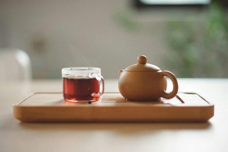 Wooden teapot and glass tea cup on a tray