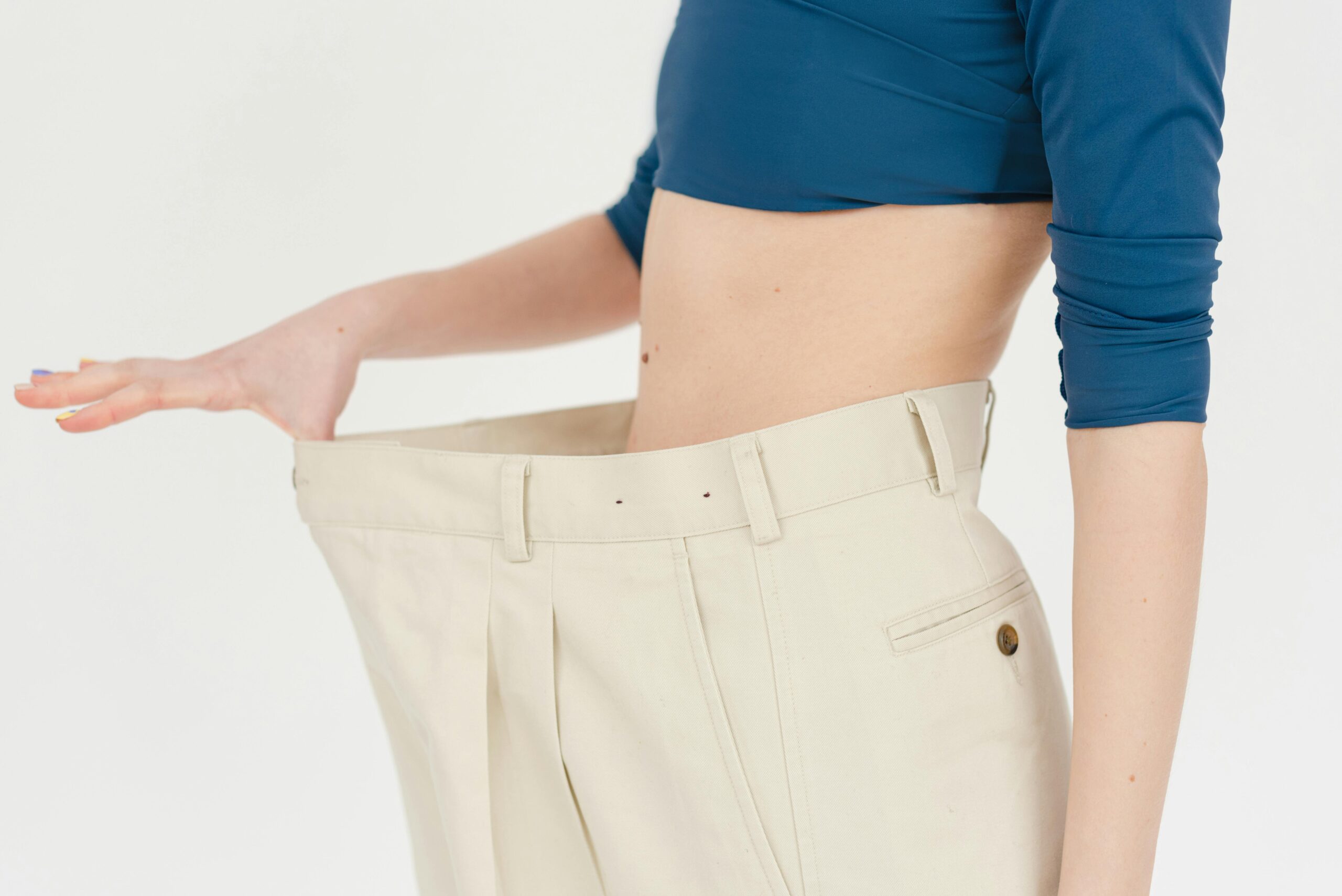 Woman in oversized pants against a plain white background