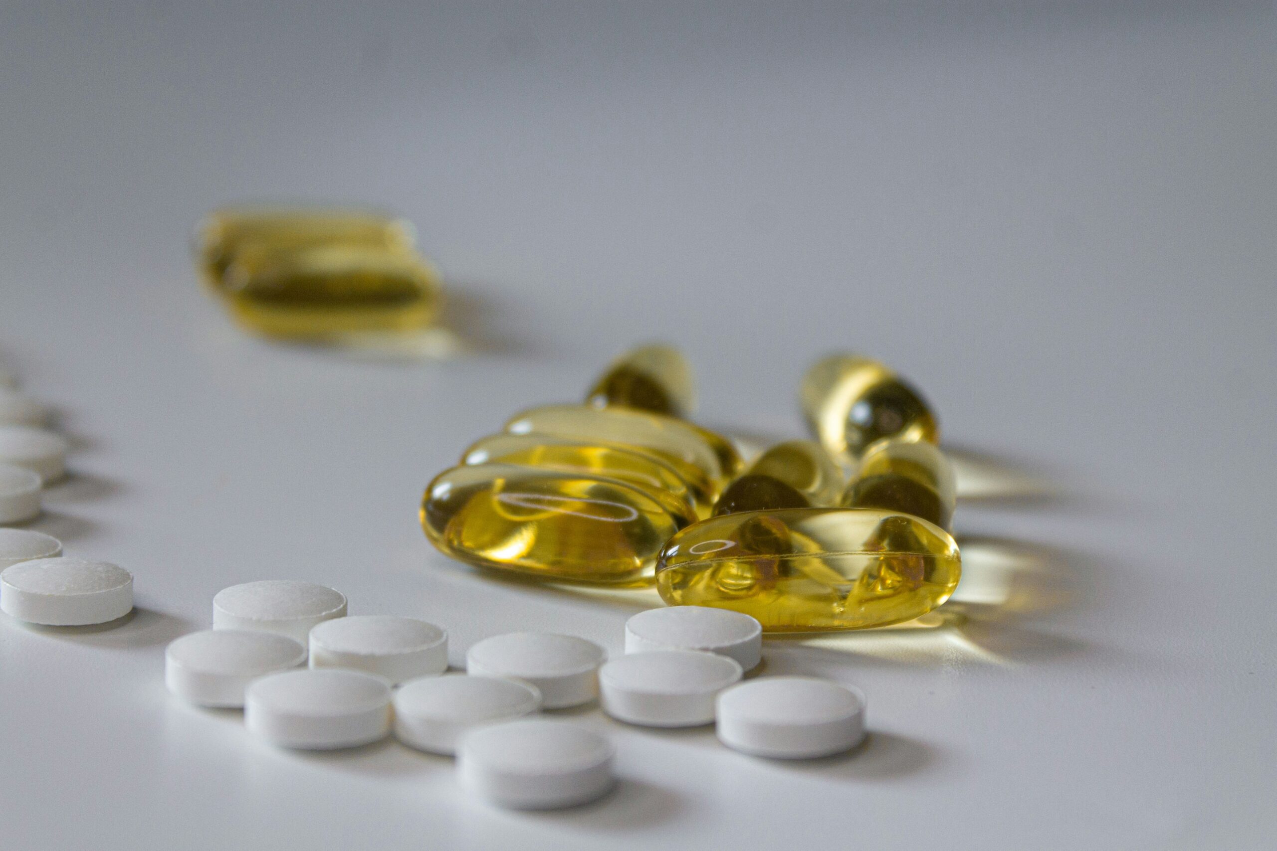 Golden and white pills on a white background