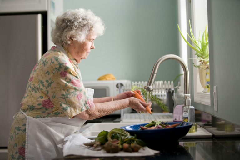 An older woman at a kitchen sink