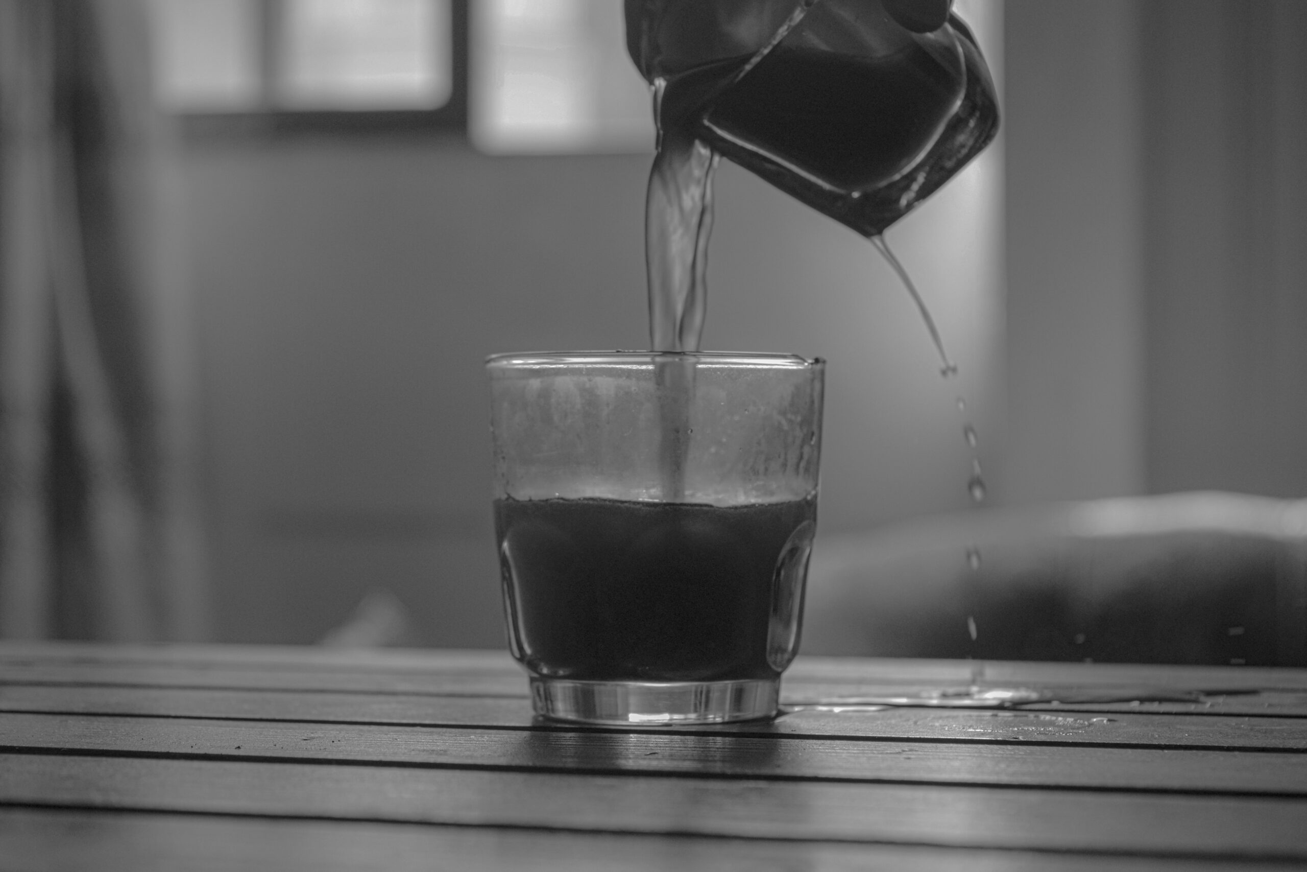 Drink pouring from a bigger cup to another